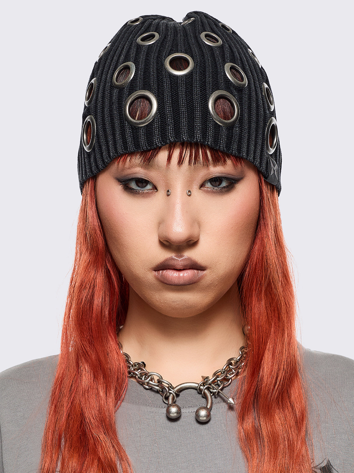 Black ribbed knit beanie with chunky silver eyelets.