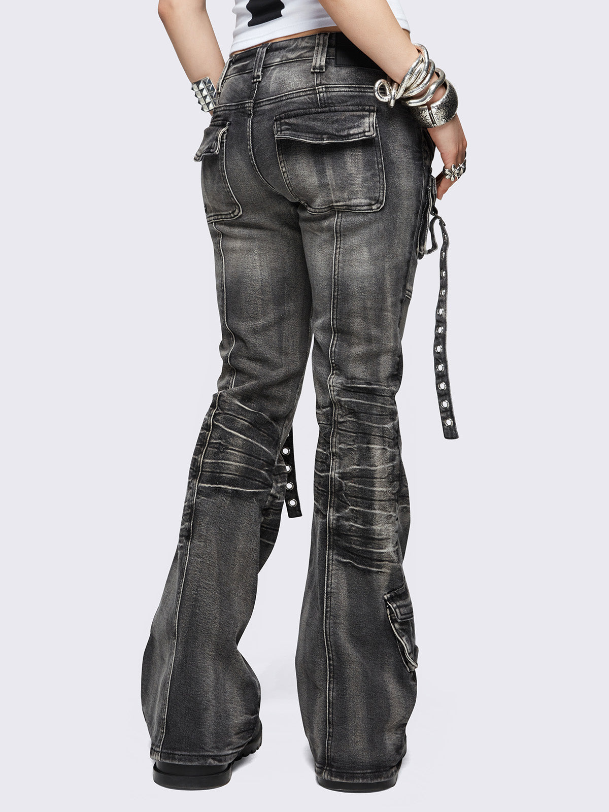 Black washed cargo flared jeans with utility pockets and straps.
