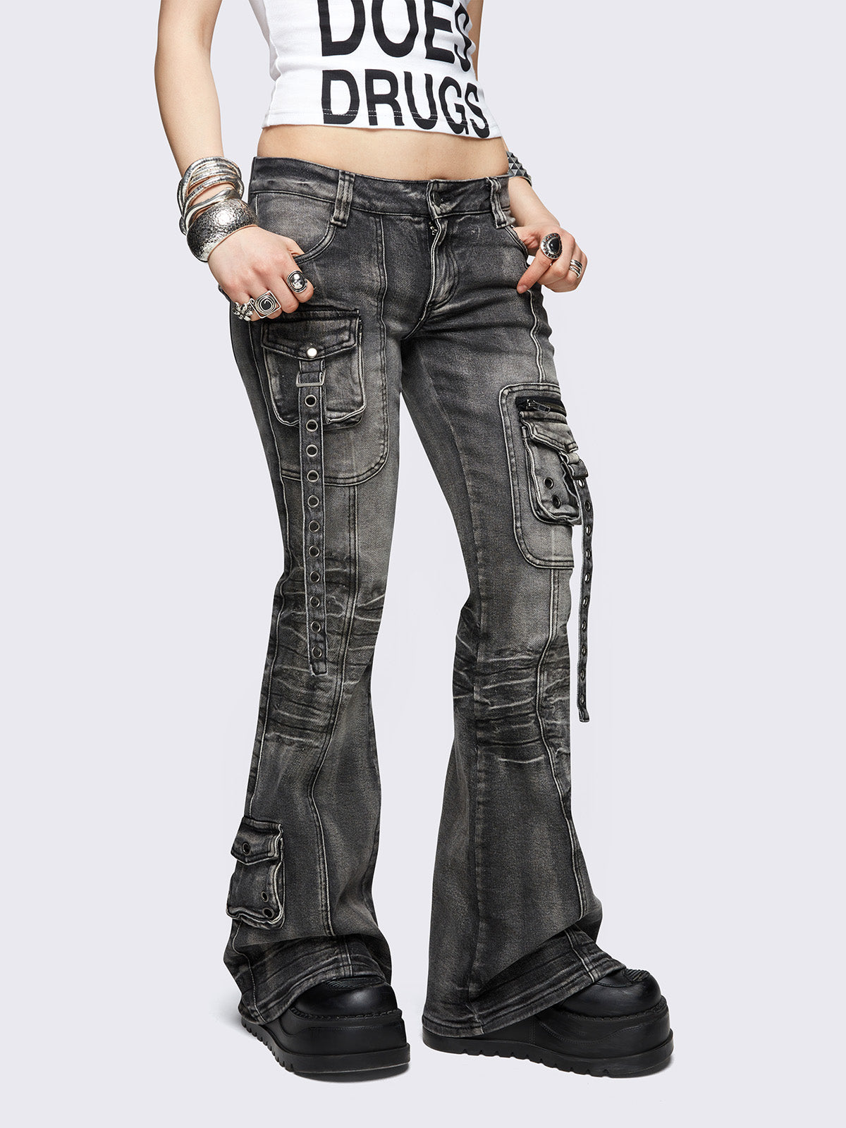 Black washed cargo flared jeans with utility pockets and straps.
