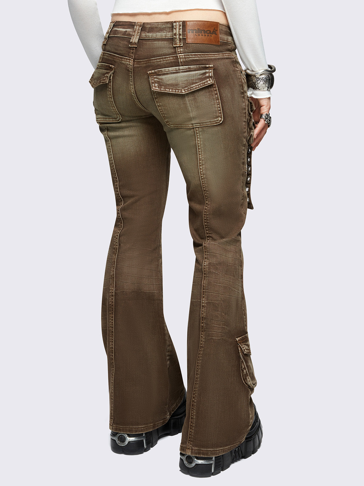 Brown washed cargo flared jeans with utility pockets and straps.