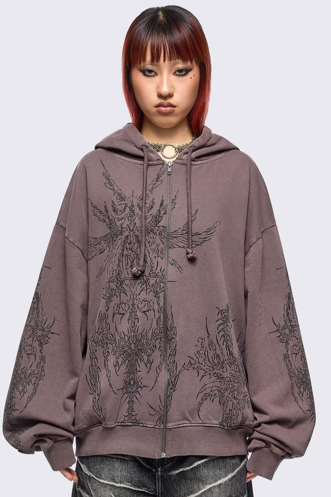 Washed brown zip-up hoodie jacket with grunge graphic prints on the front and sleeves.