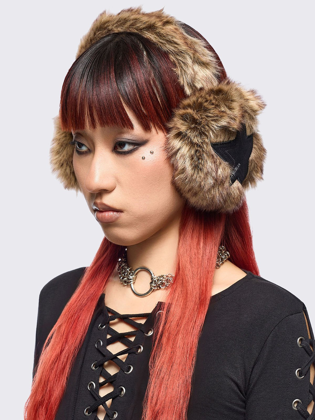 Faux fur earmuffs in beige and brown featuring stars embroidered patch in black.