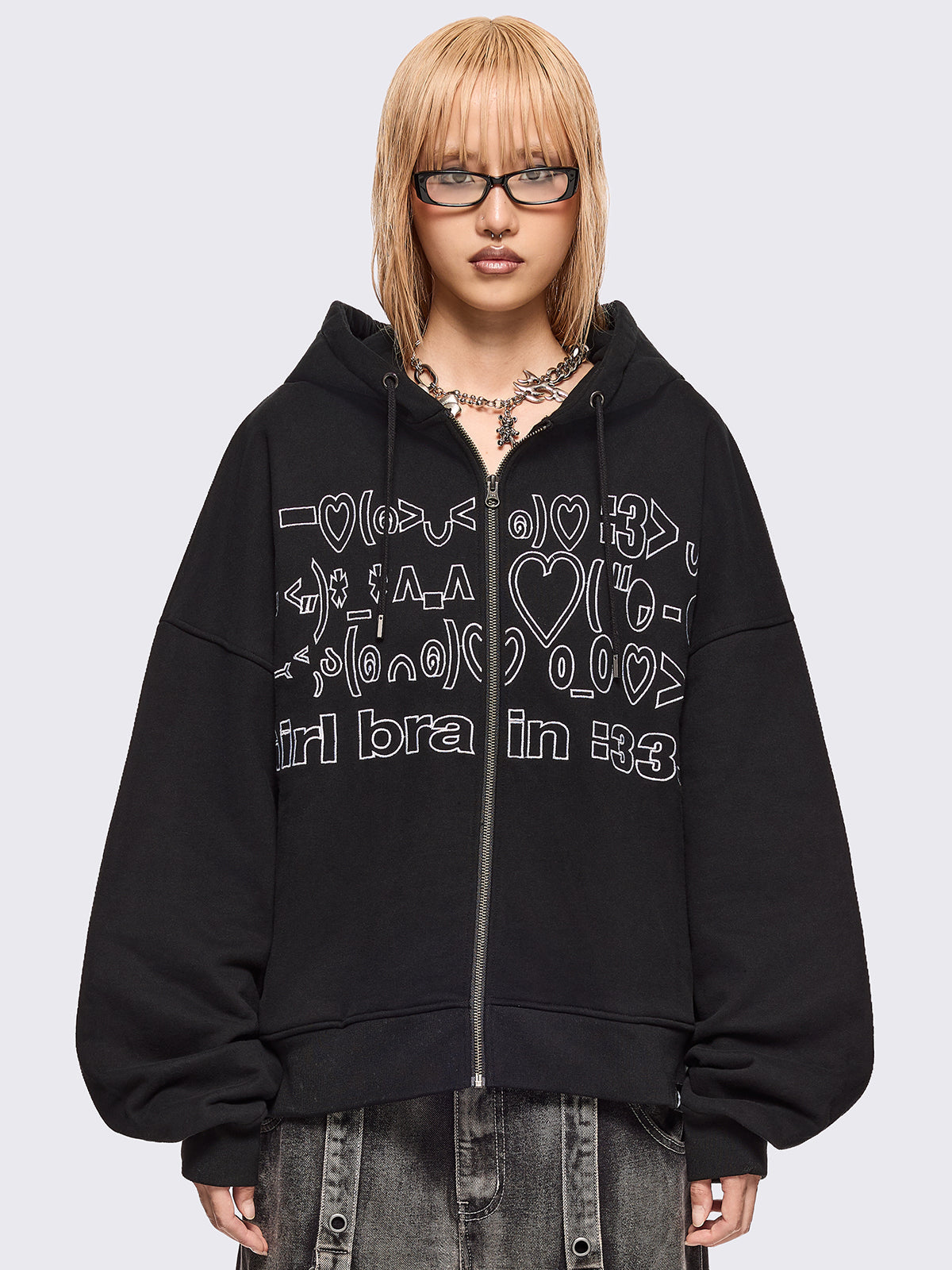Black zip up hoodie jacket featuring a kaomoji ASCII-style embroidery in white.