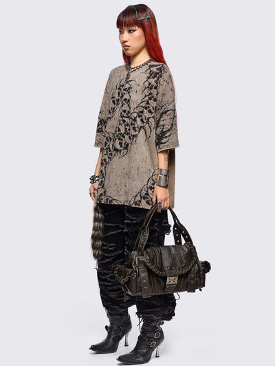 Brown faux leather shoulder bag featuring lace ups, eyelets, buckles and multiple pockets.