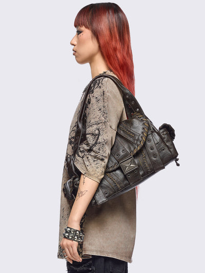 Brown faux leather shoulder bag featuring lace ups, eyelets, buckles and multiple pockets.