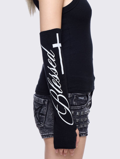 Black knitted arm warmers with white "blessed" cross print.