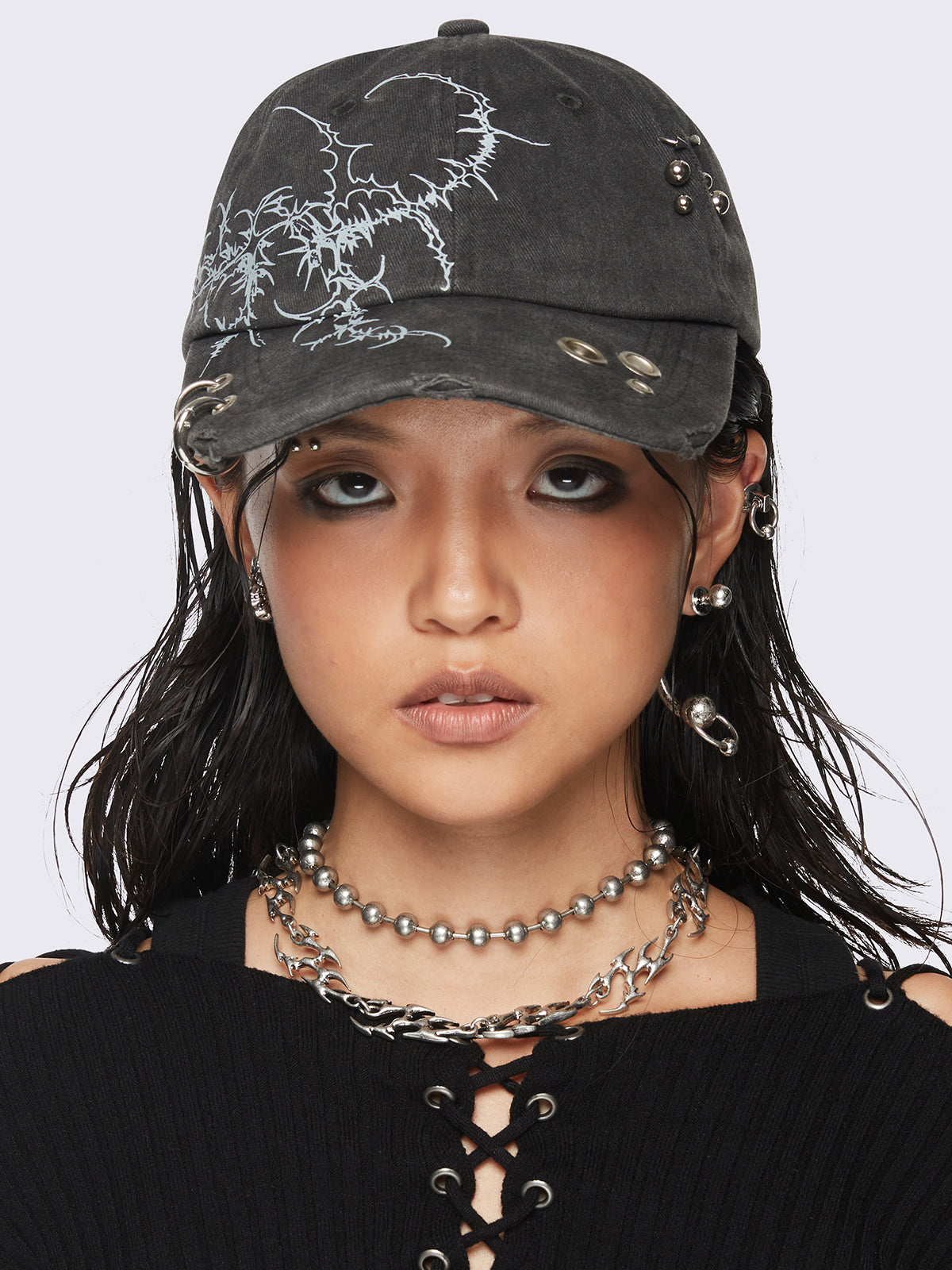 Black washed baseball cap with
Sigilism graphic print and distressed, eyelet and piercing details.