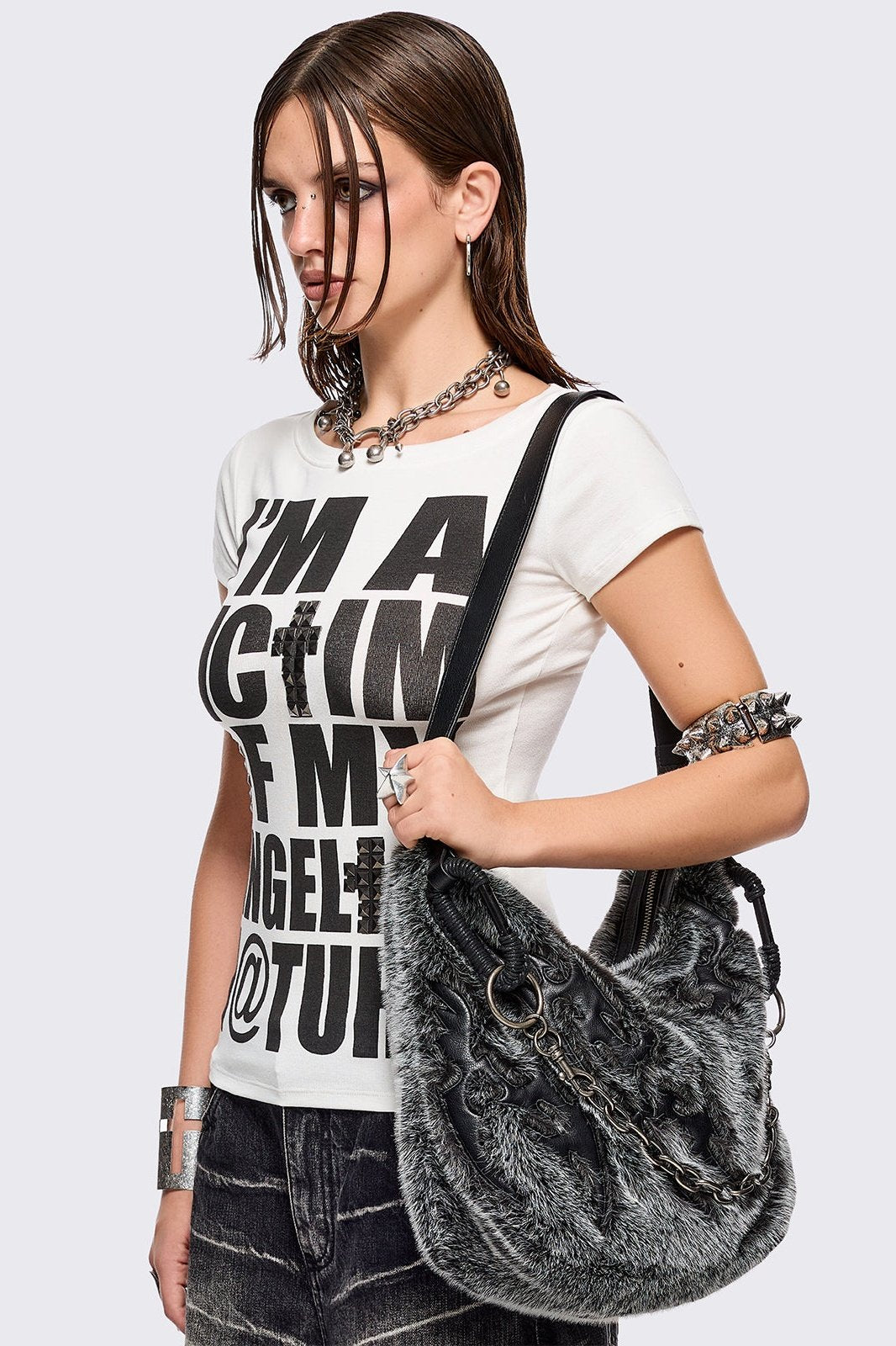 Black and grey faux fur shoulder bag with sigilism patches and silver chain detail.