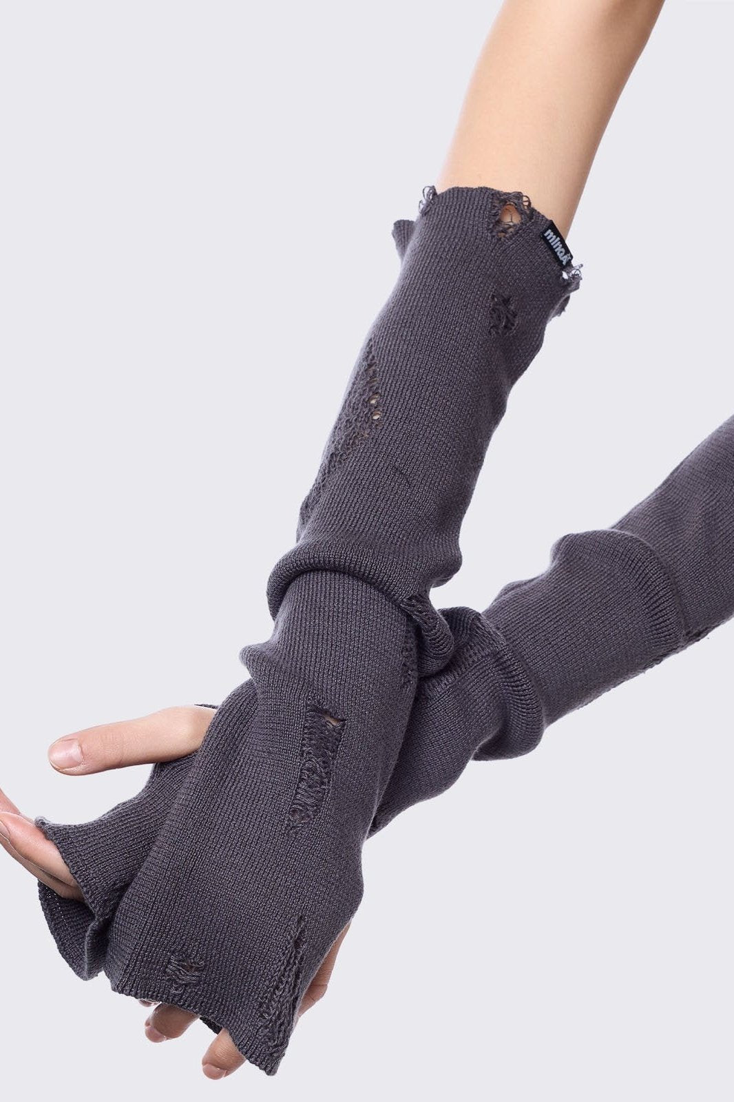 Grey knitted arm warmers with distressed details and thumbhole cuffs