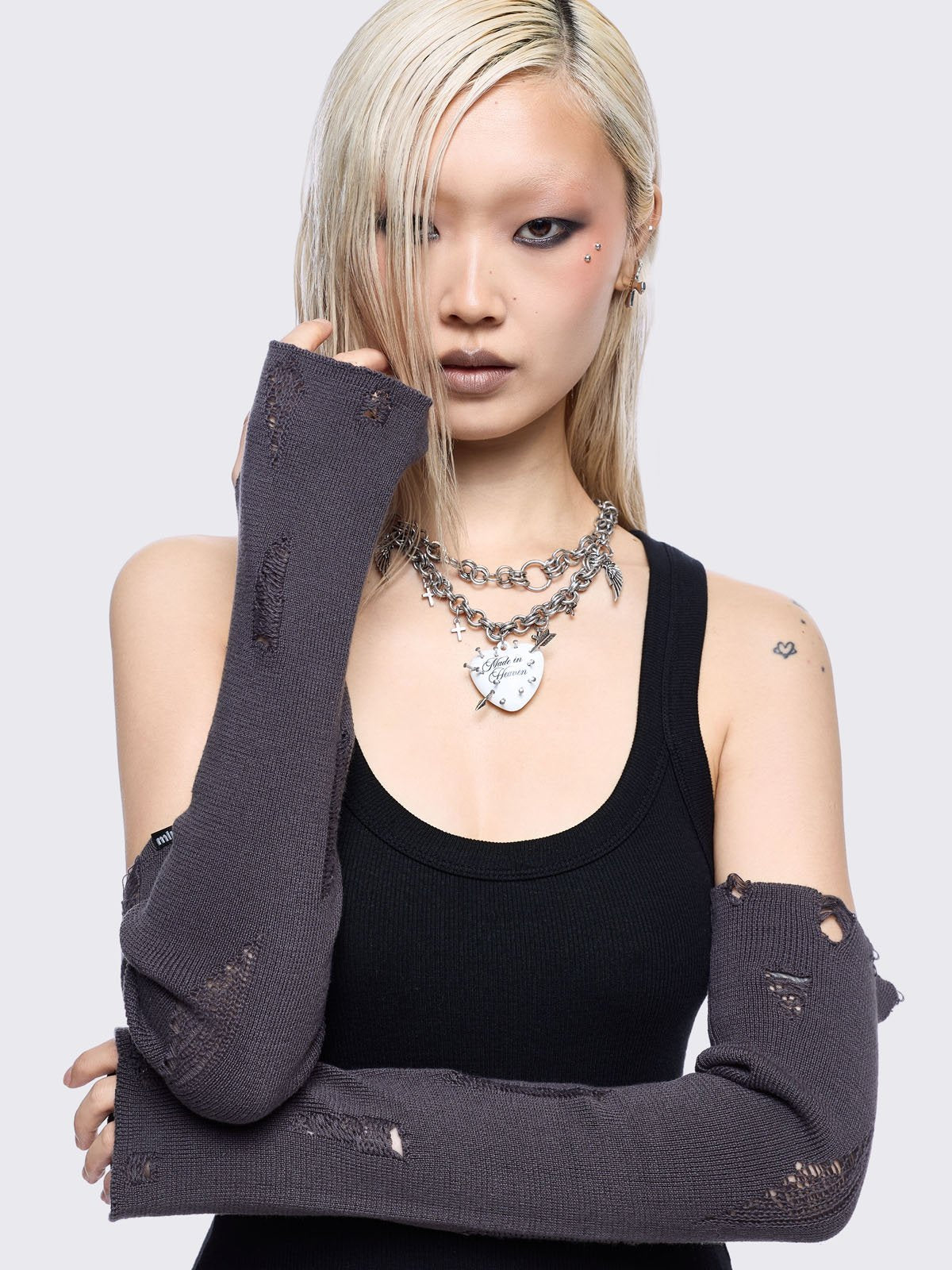 Grey knitted arm warmers with distressed details and thumbhole cuffs