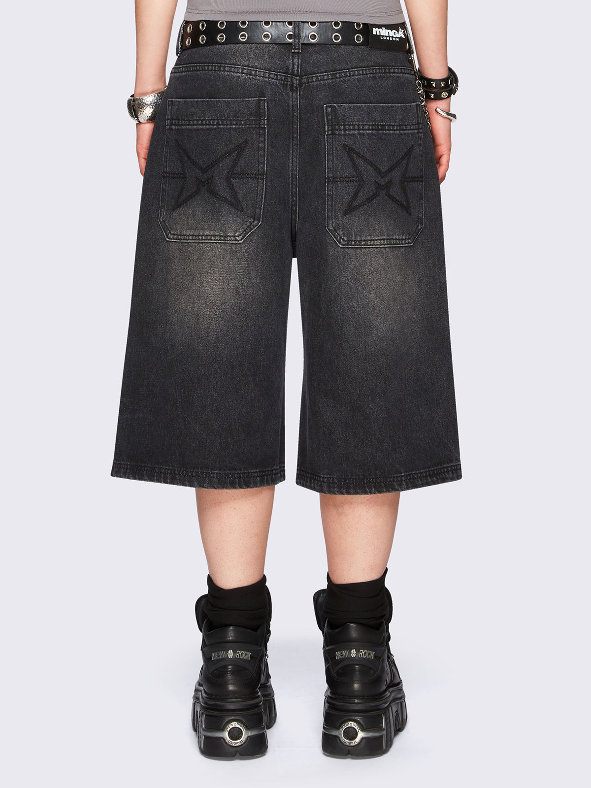 Black washed longline denim jorts with removable chain and wide-leg fit and knee-length cut.