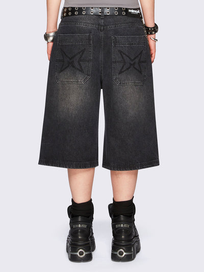 Black washed longline denim jorts with removable chain and wide-leg fit and knee-length cut.