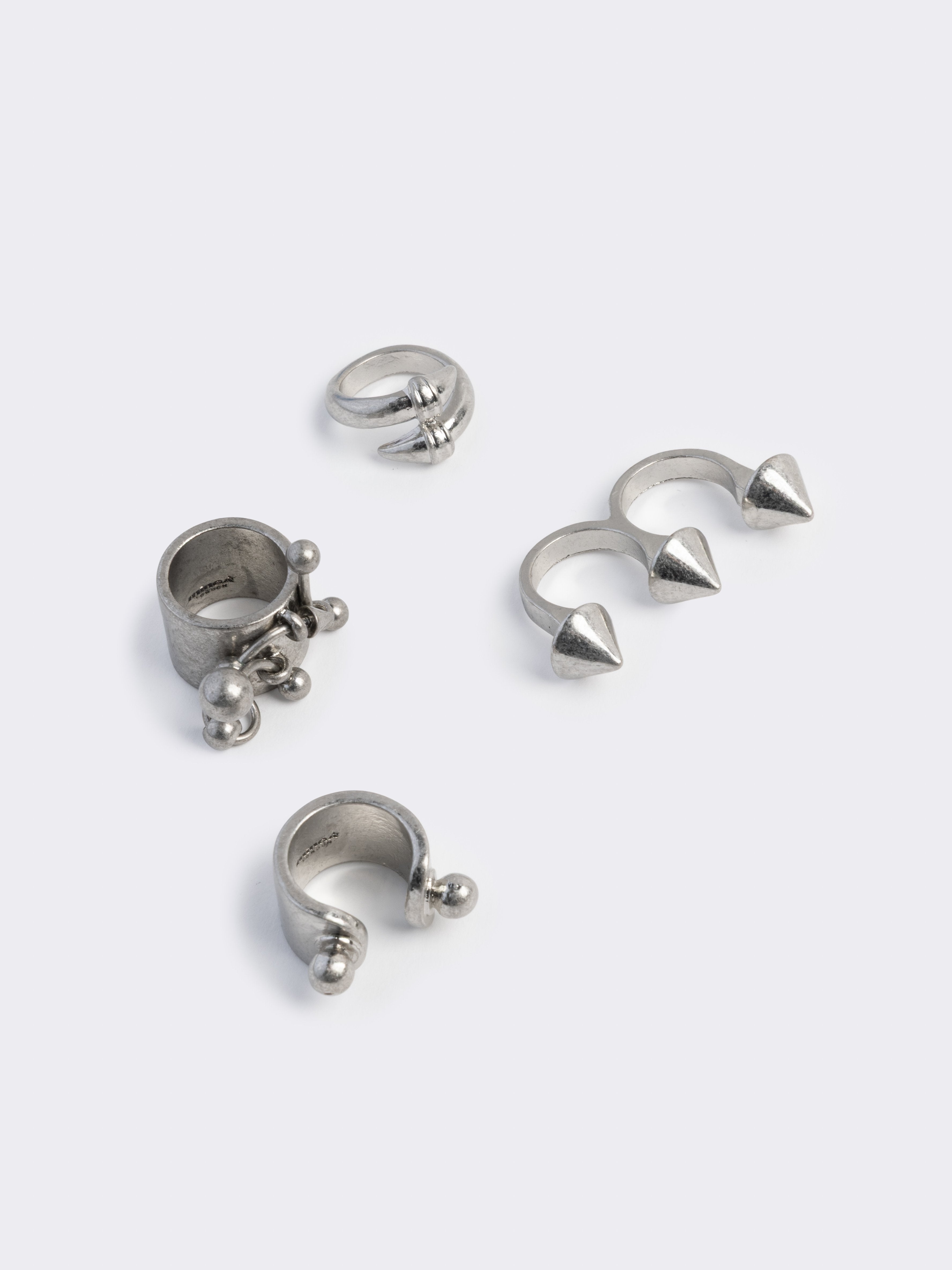 Set of 4 silver rings featuring piercing and spike designs