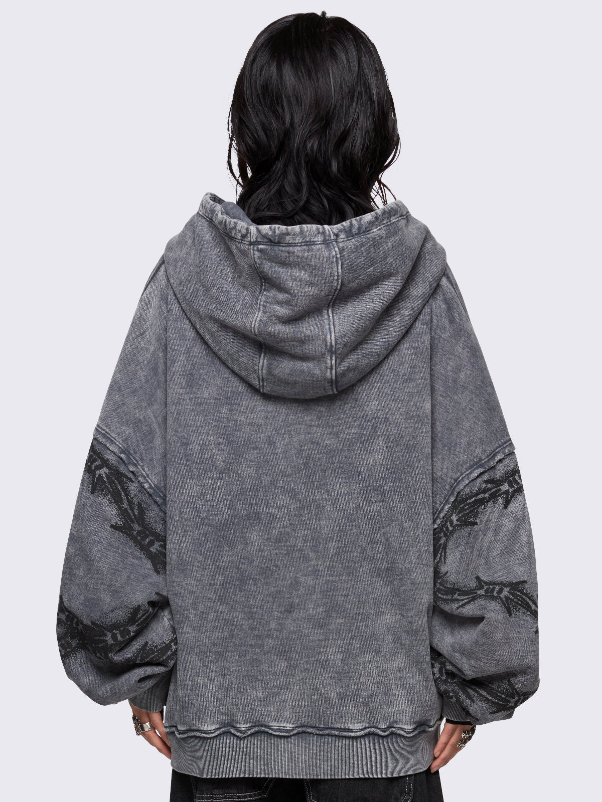 Grey distressed wash zip-up hoodie with a black barbed wire and spiderweb graphic, oversized fit, and dropped shoulders for a bold grunge aesthetic.