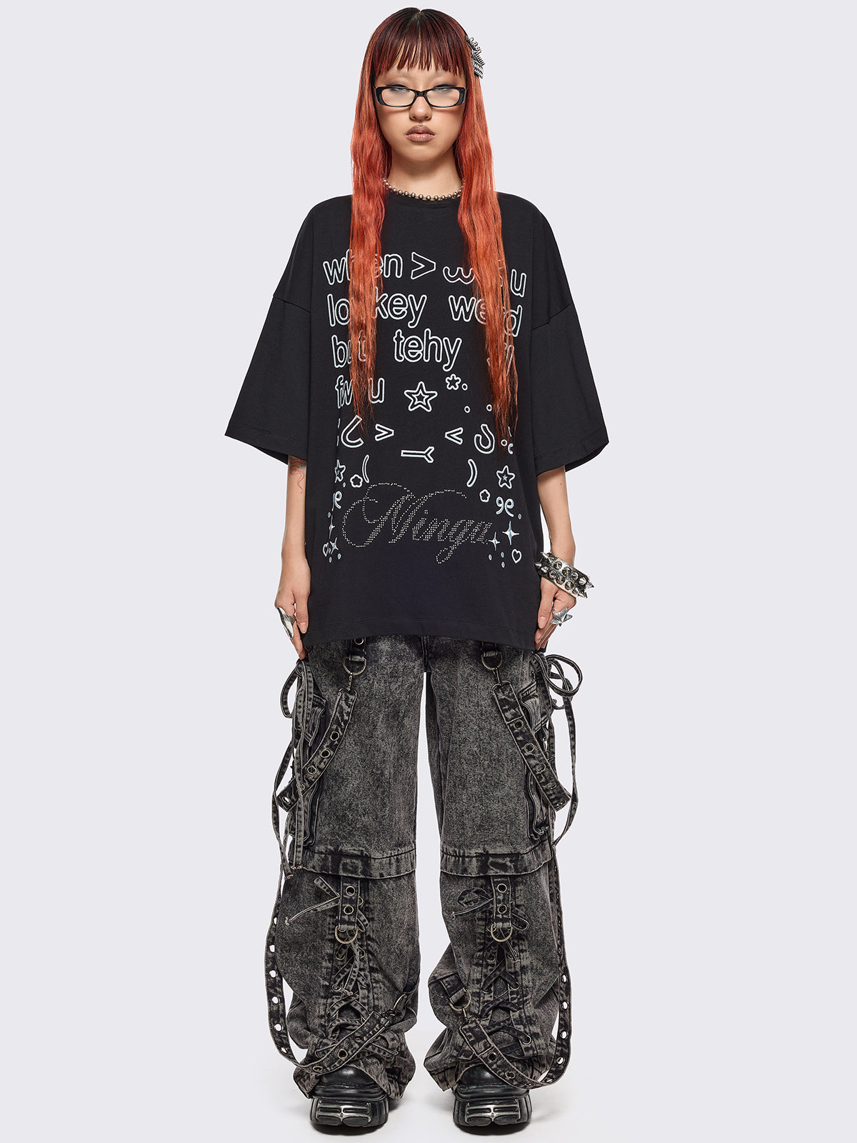 Black oversized t-shirt with "when u lowkey weird but tehy stil fw u" graphic print, kaomoji ASCII-style embroideries and stud details.