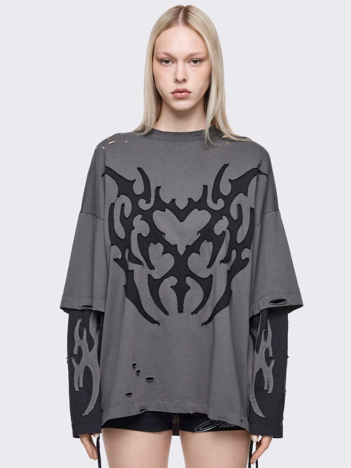 Grey distressed layered long sleeve t-shirt with heart and sigilism patches featuring contrast black sleeves.