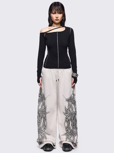 Black cold shoulder top with cut out details and white contrast stitching.