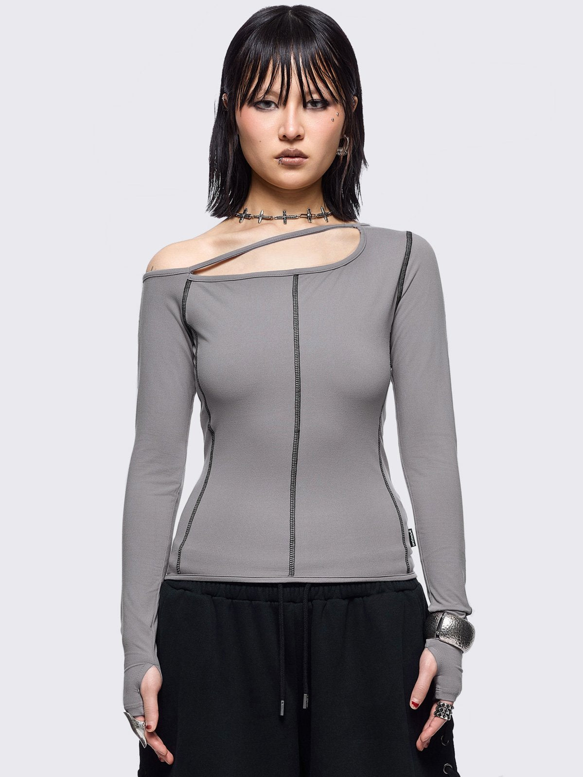Grey cold shoulder top with cut out details and black contrast stitching.