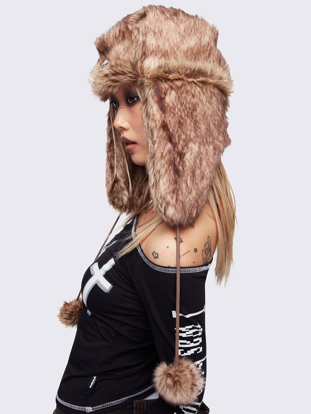 Beige faux fur trapper hat with minga rubber logo detail and ear flaps