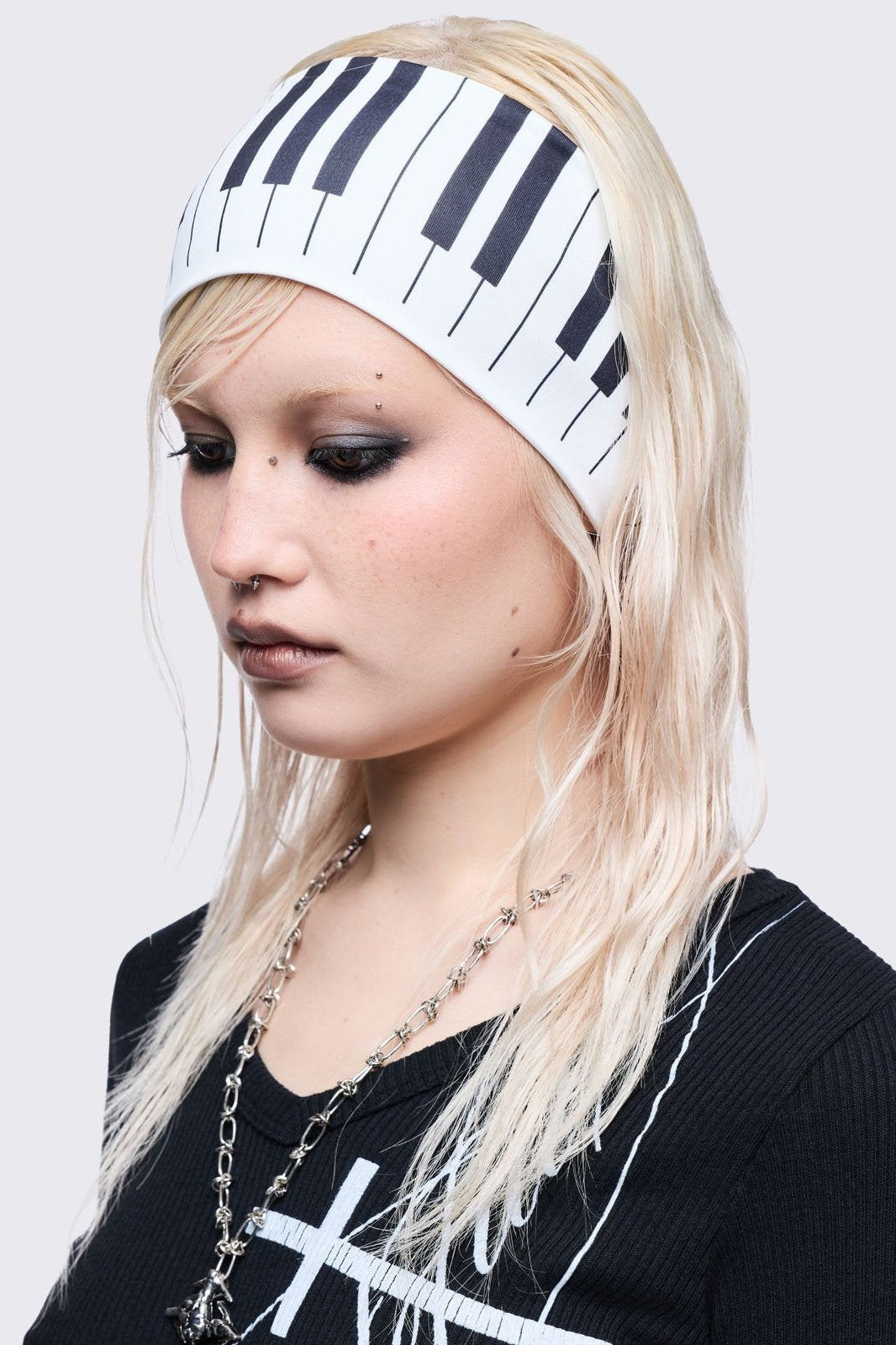 White wide headband with piano graphic print. 