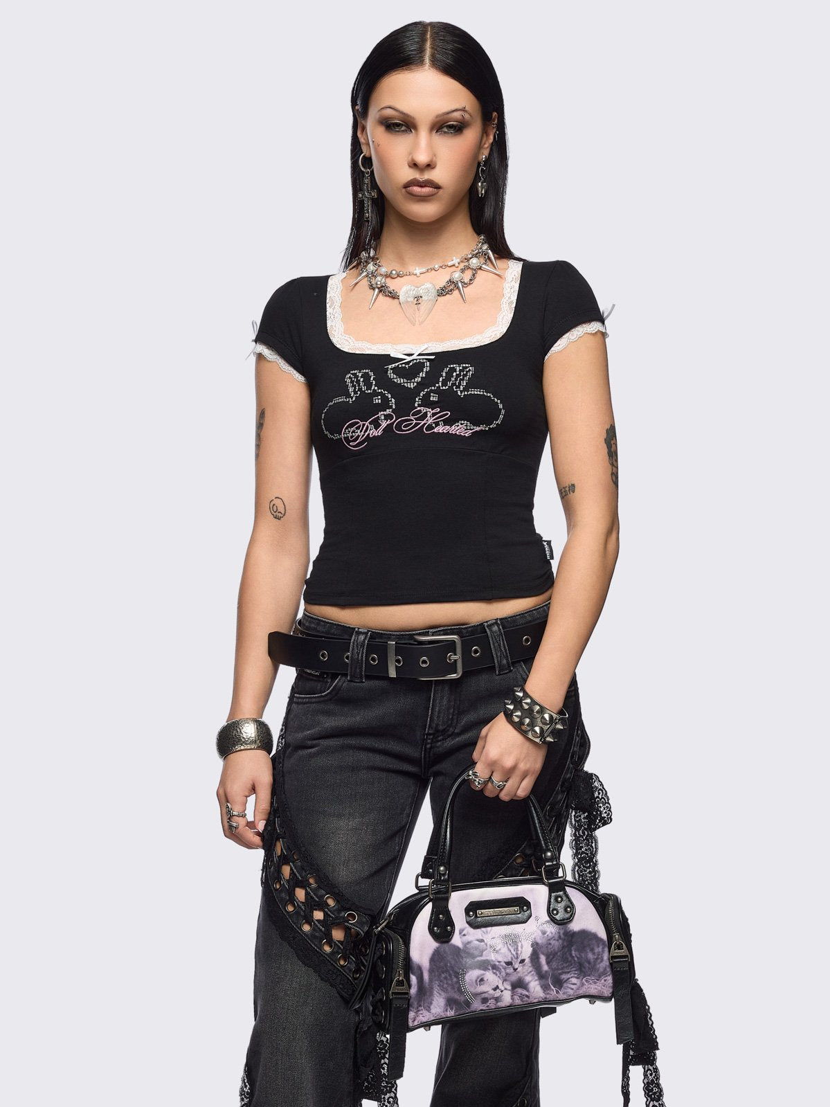 Black and pink bowling bag with kittens graphic print, rhinestone details and side exterior pockets with lace up bows.