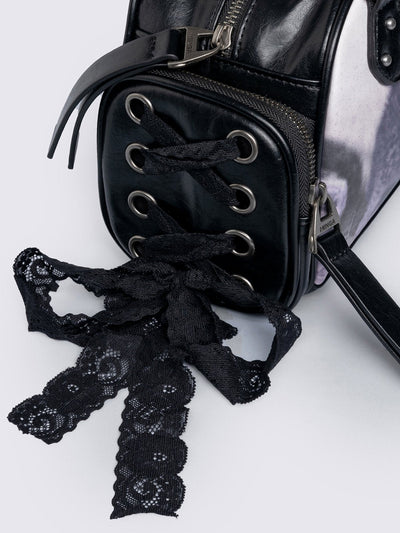 Black and pink bowling bag with kittens graphic print, rhinestone details and side exterior pockets with lace up bows.