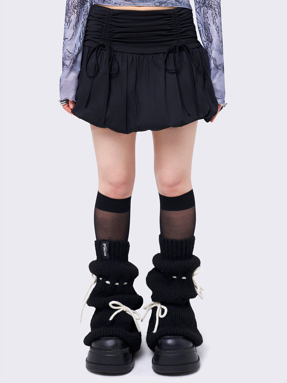 Black puffball mini skirt with a ruched tie-front and bow detail, featuring a voluminous balloon-style silhouette.