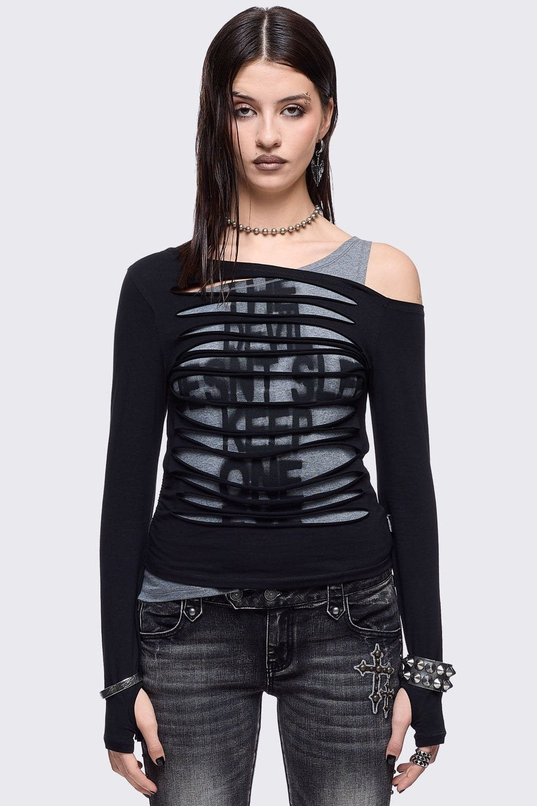 Black and grey long sleeve layered cold shoulder top featuring a front cut-out slash details and a grunge graphic print. 