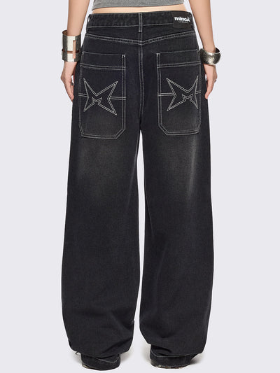 Black baggy wide leg jeans featuring a multi grunge graphic prints with white contrast stitching.