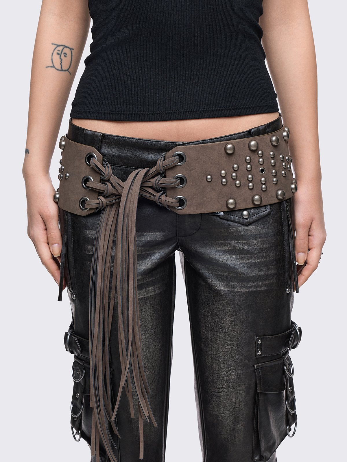 Brown faux leather wide belt with silver eyelets, studs and long tassel fringe.