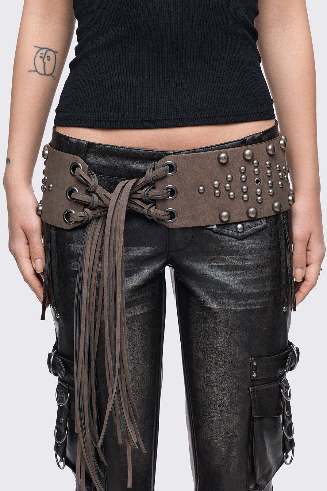 Brown faux leather wide belt with silver eyelets, studs and long tassel fringe.