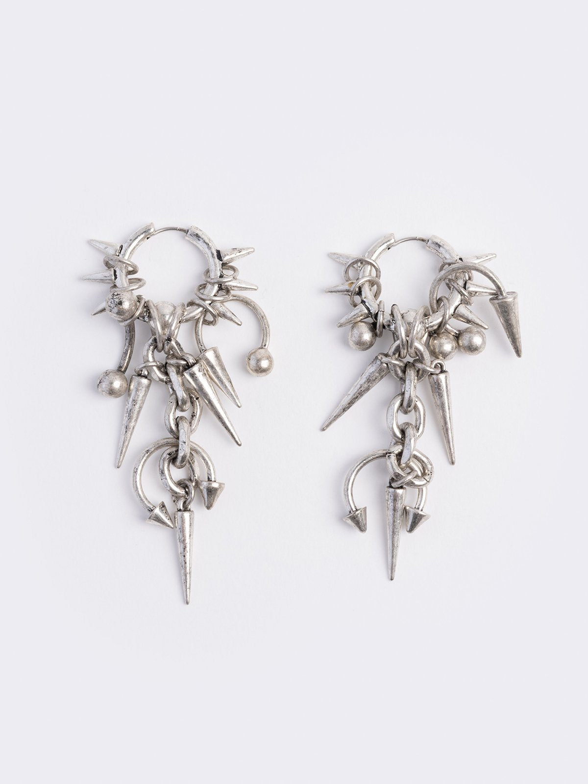 Silver chunky hoop earring with spike and piercing pendants.