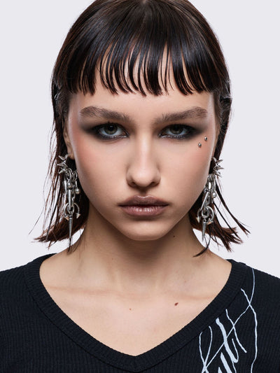 Silver chunky hoop earring with spike and piercing pendants.