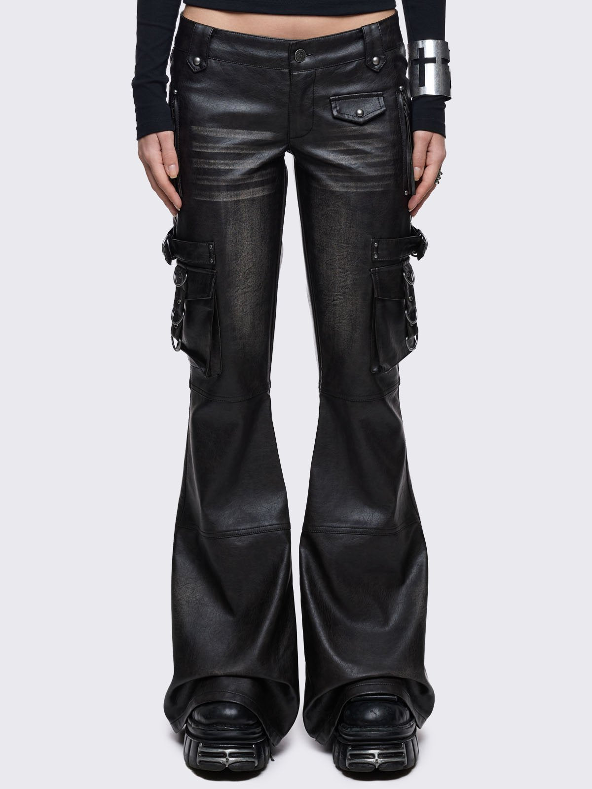 Low-rise black vegan leather pants with a dramatic flared leg, featuring oversized 3D cargo pockets with silver hardware and a vintage washed effect.