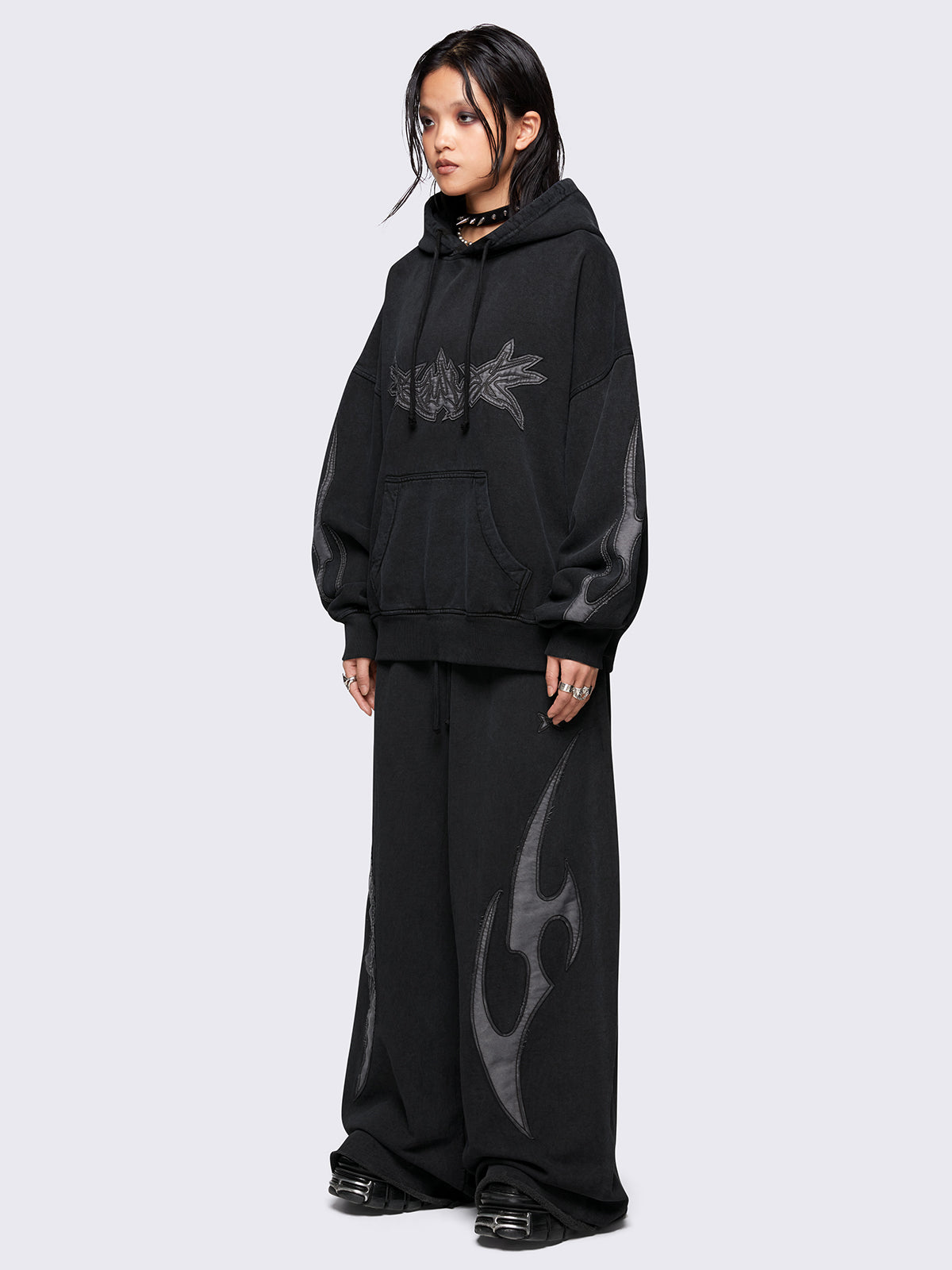 Black washed hoodie with grey sigilism embroidered patches, drawstring hood, and kangaroo pockets.