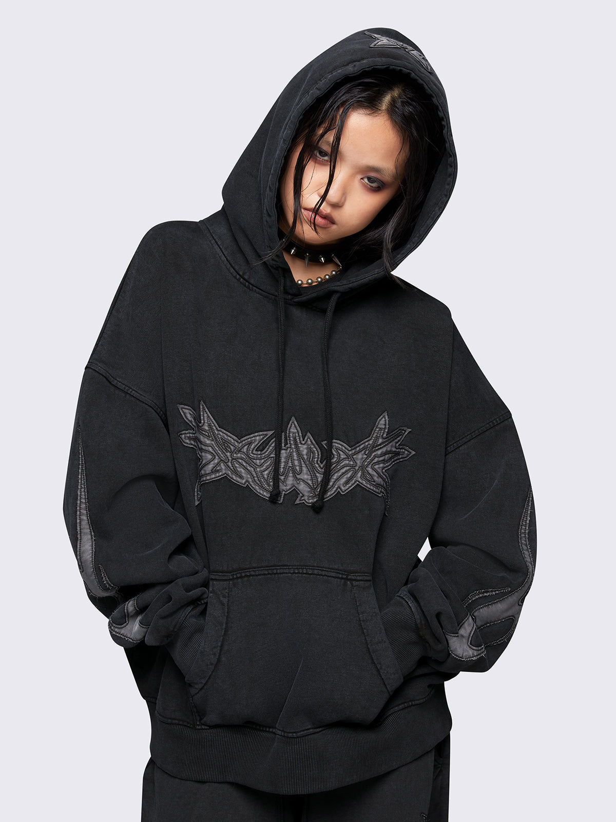 Black washed hoodie with grey sigilism embroidered patches, drawstring hood, and kangaroo pockets