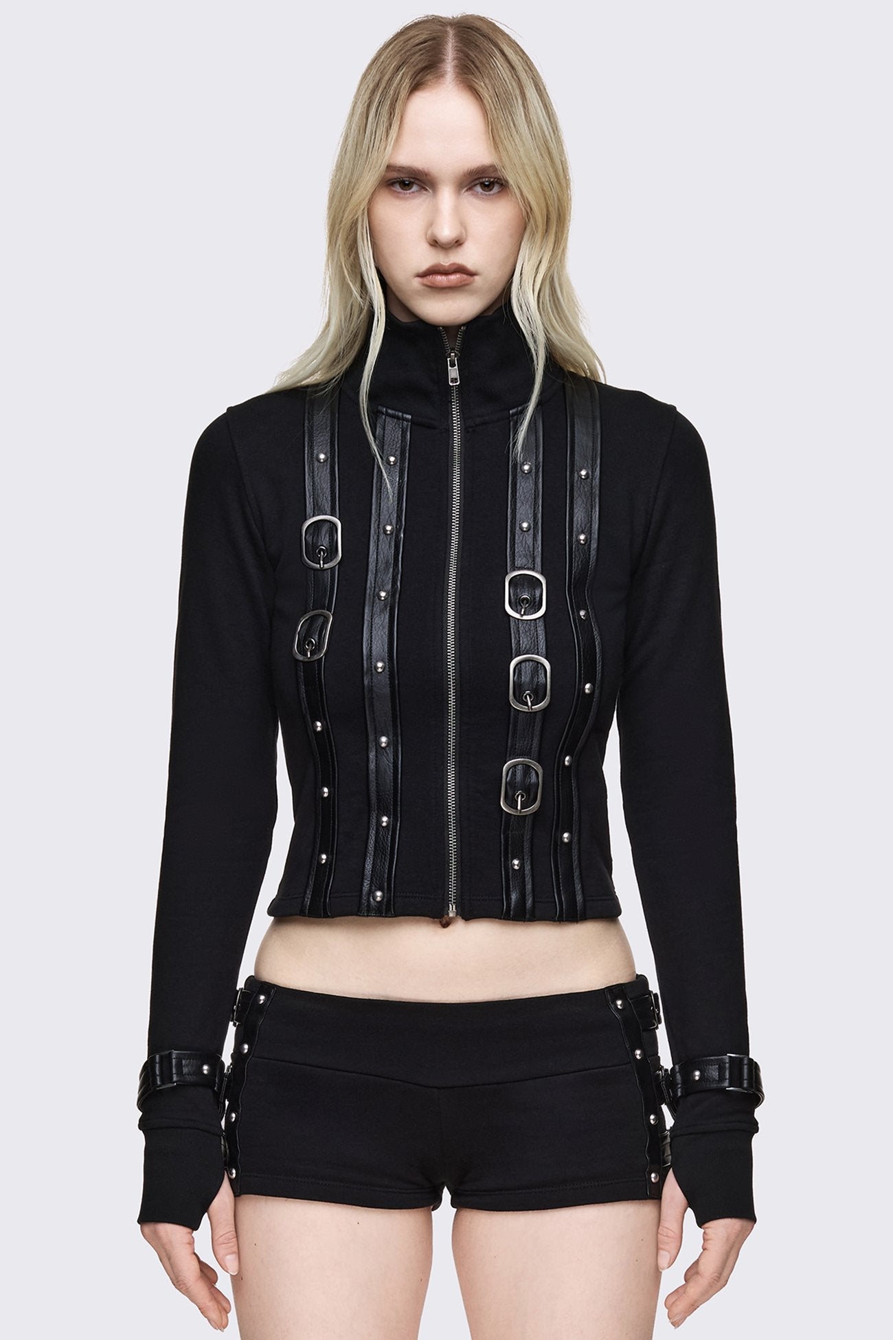 Black cropped zip up cardigan with faux leather buckle straps, silver studs, high neck and slim fit.