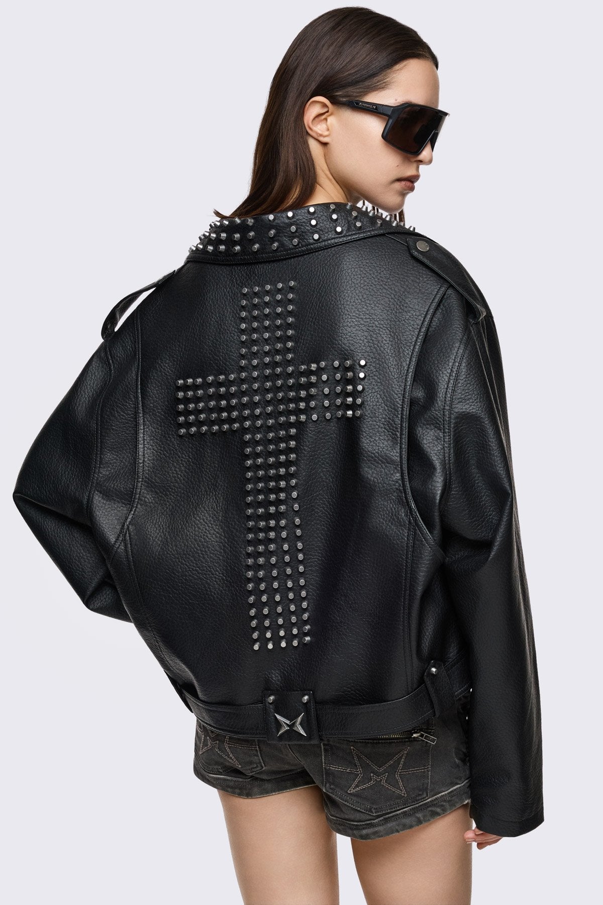 Black vegan leather jacket with stud details and a cross on back.