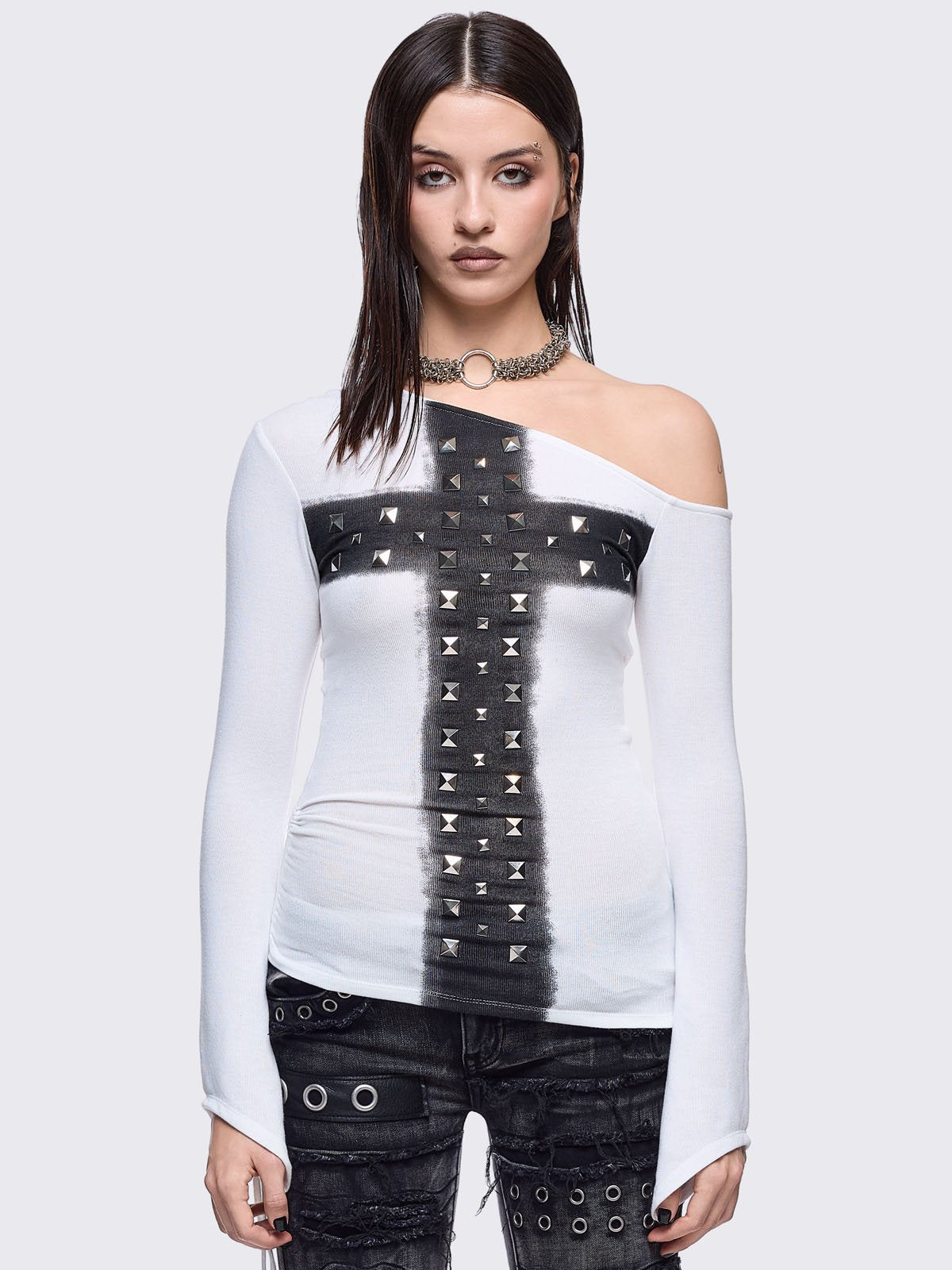 White off-shoulder top featuring a black chunky cross with silver square studs and ruched tie side detail.