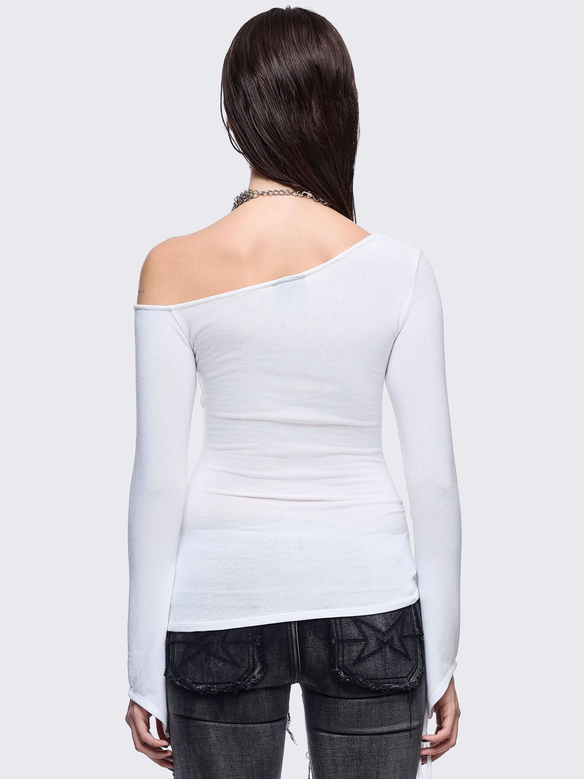 White off-shoulder top featuring a black chunky cross with silver square studs and ruched tie side detail.