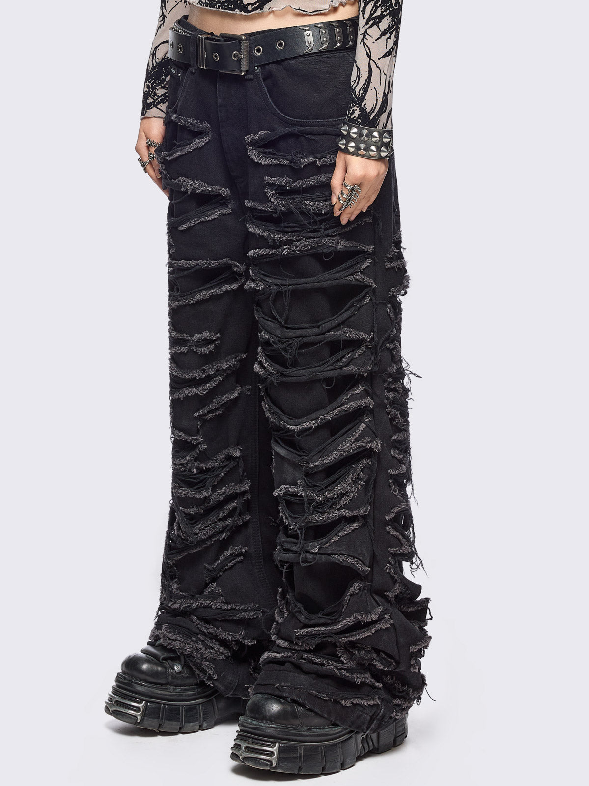 Black baggy jeans featuring distressed cut-out slashed legs.