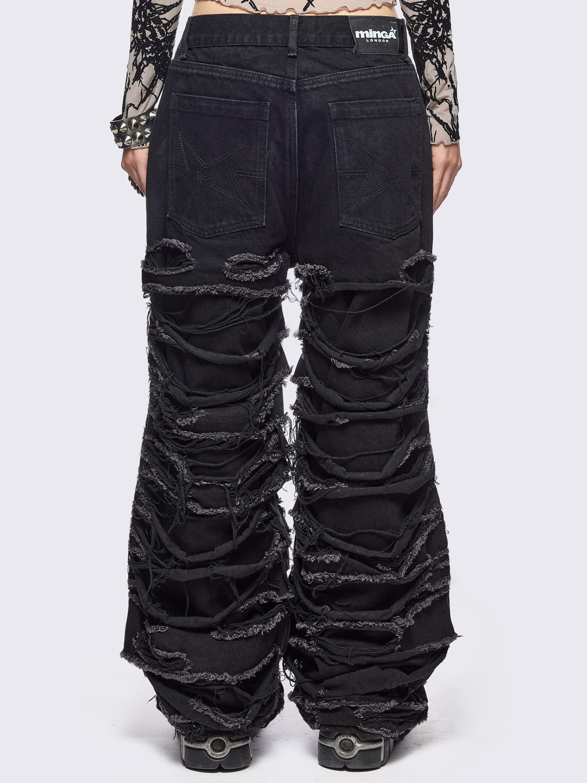 Black baggy jeans featuring distressed cut-out slashed legs.