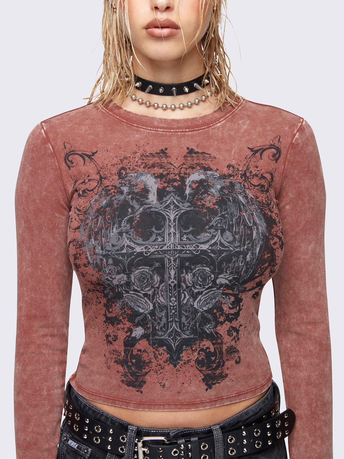 Long sleeve top in washed terracotta red with winged cross front graphic print.