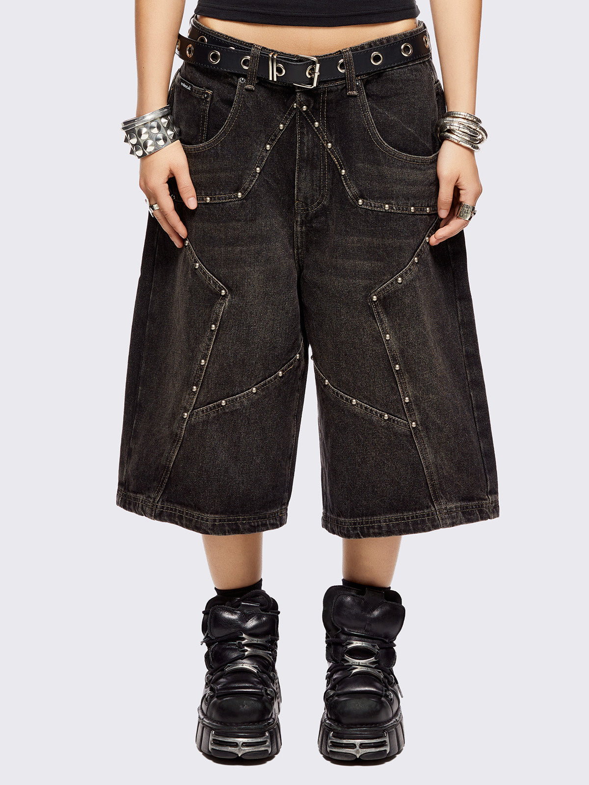 Black washed longline denim shorts with star-shaped stud and seam detail on front.