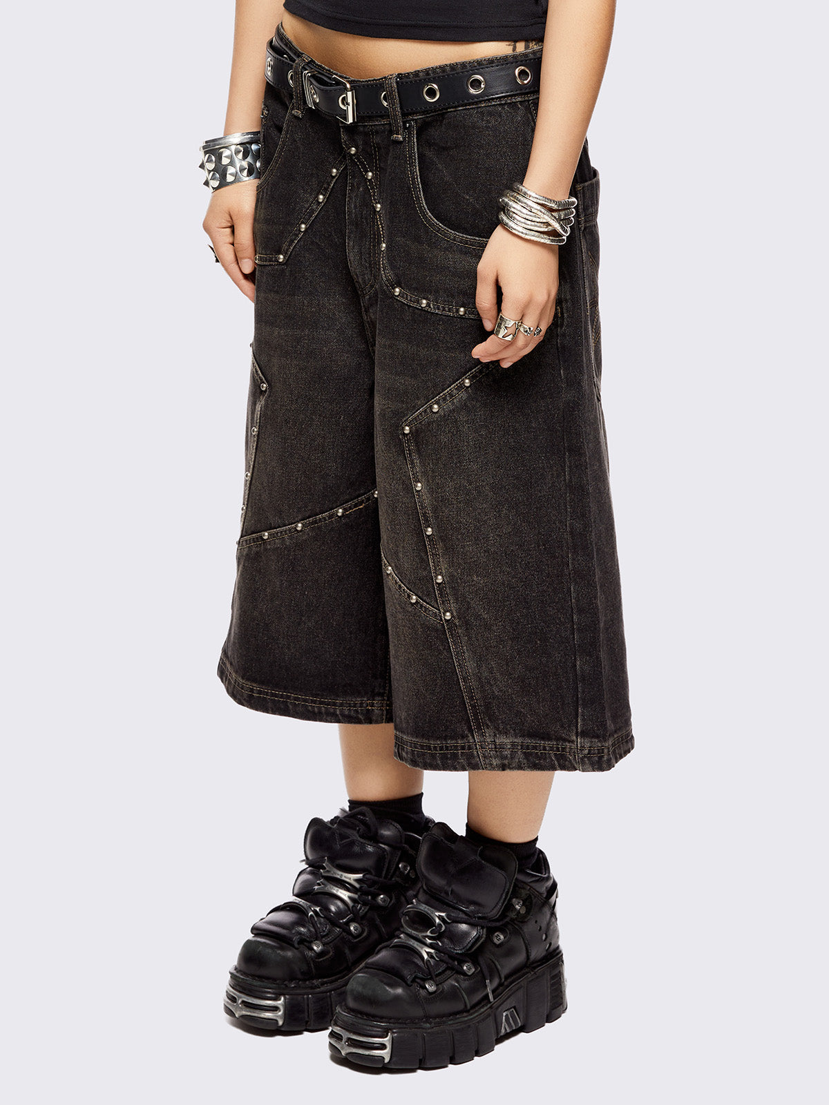 Black washed longline denim shorts with star-shaped stud and seam detail on front.