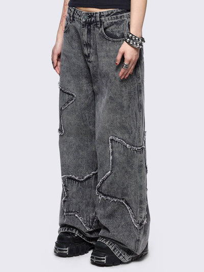 Grey washed baggy jeans with frayed star patches.