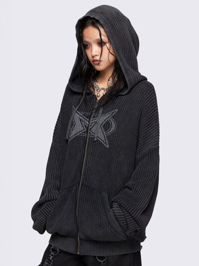 Black washed oversized hoodie cardigan featuring a signature graphic front print. Designed with a chunky ribbed knit, drawstring hood, zip fastening, and kangaroo pockets. The drop shoulders and long sleeves enhance its relaxed, streetwear-inspired fit.