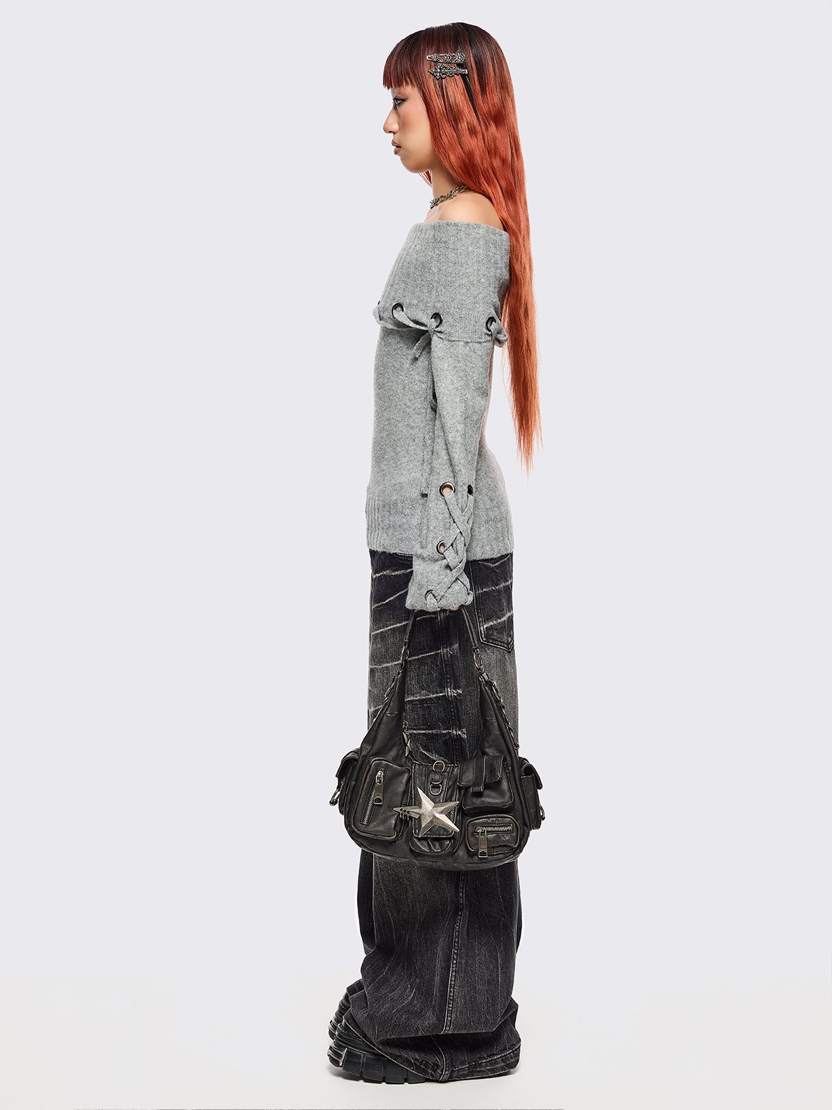 Black washed faux leather shoulder bag with silver star clasp, hardware details and multiple pockets.