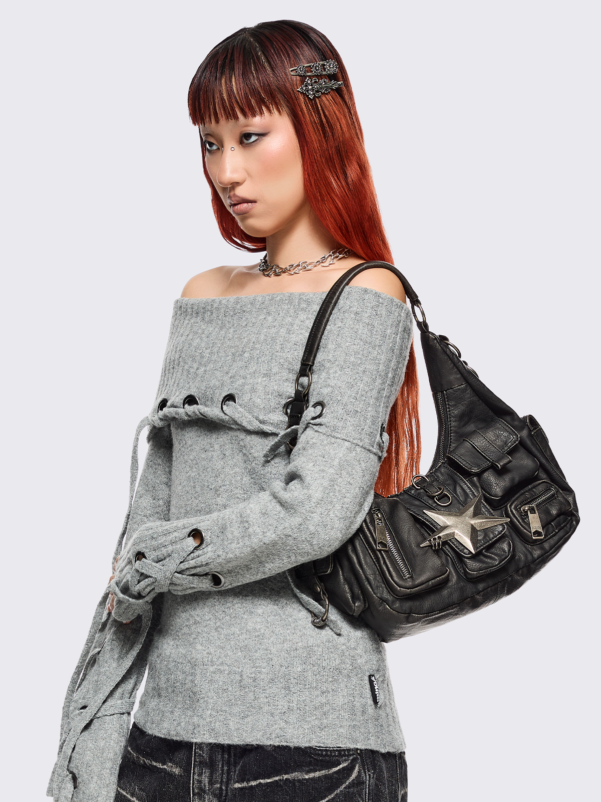 Black washed faux leather shoulder bag with silver star clasp, hardware details and multiple pockets.