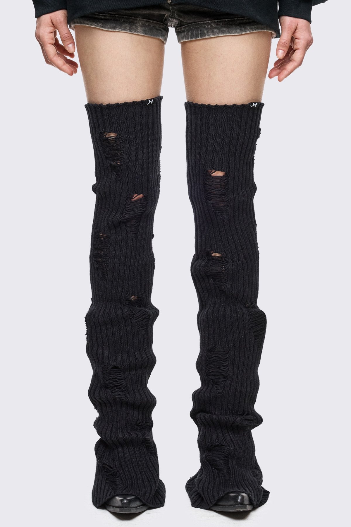 Black rib-knit thigh-high leg warmer with shredded distressed details in a grunge style.